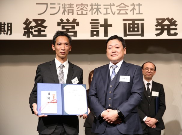 表彰状をもっている写真